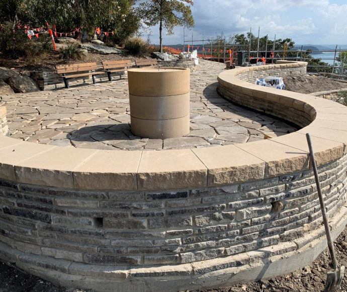 Reinstatement of the existing sandstone paving and curved seating at lookout with view over the water