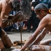 Two men share the Aboriginal cultural tradition of fire starting with visitors in Sydney Harbour National Park.