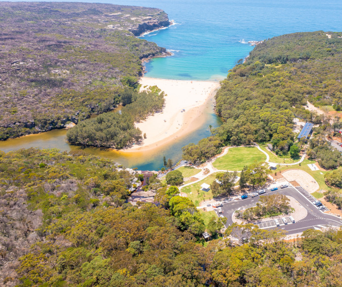 Aerial view of beach, visitor precinct and surrounding bushland at Wattamolla, Royal National Park