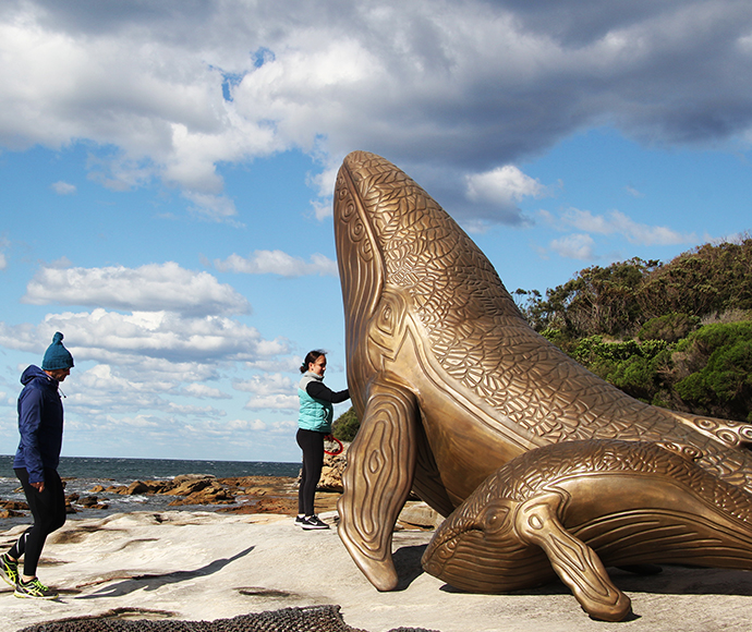 Whale Sculptures at Kurnell Area: Large sculptures shaped like whale bones situated near the shoreline in Kamay Botany Bay National Park. The sculptures honor Aboriginal cultural heritage and are set against a backdrop of water and grassy dunes.