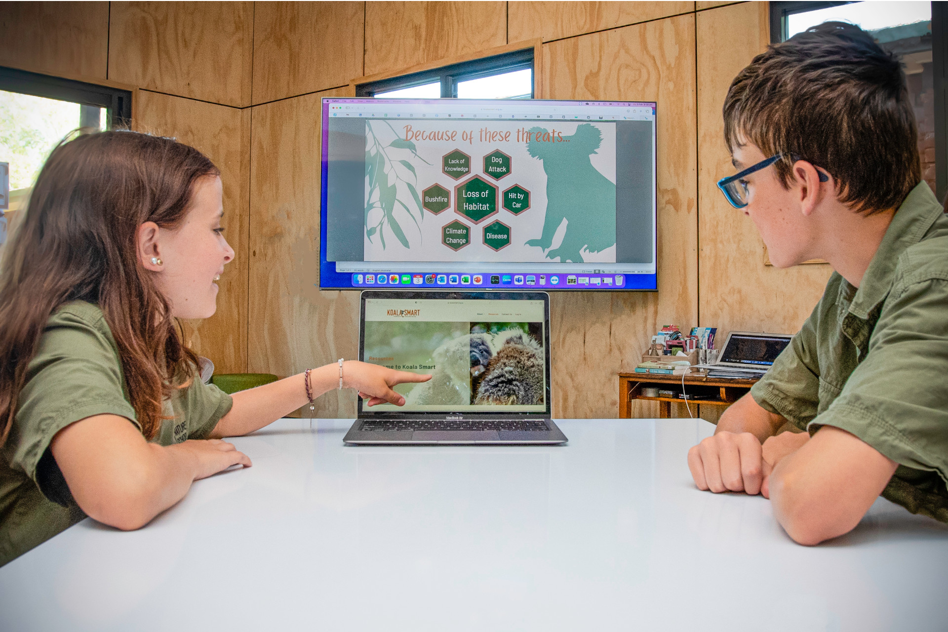 Two children learning about koala food trees on a computer.